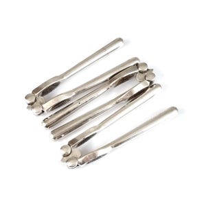 Puede incluir: Un juego de cinco cascanueces de plata con un diseño decorativo. Los cascanueces están plegados juntos y tienen un borde dentado para romper nueces.