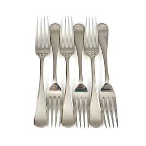 Könnte beinhalten: Sechs Silber-Gabeln auf weißem Hintergrund. Die Gabeln haben ein klassisches Design mit drei Zinken und einem abgerundeten Griff. Das Besteck ist wahrscheinlich Vintage oder antik und misst etwa 20 cm.