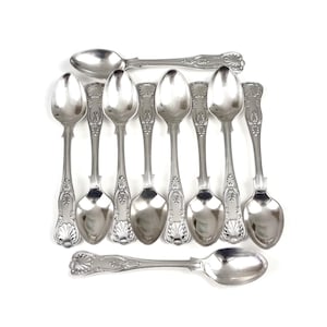 May include: A set of silver spoons with decorative handles and oval bowls, arranged on a white surface. The spoons' reflective surfaces highlight the intricate patterns on the handles. These spoons are likely for serving or eating.