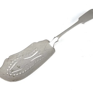 May include: A silver serving spoon with a decorative, openwork design. The spoon has a long, slender handle and a wide, flat bowl with a scalloped edge.