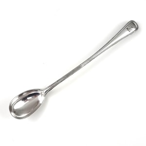 May include: A silver spoon with a long handle and a rounded bowl. The handle has a beaded design and an engraved monogram.