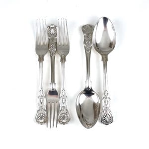 Può includere: Set di posate d'argento con manici decorati, tra cui tre forchette e un cucchiaio.