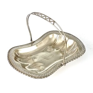 May include: Silver serving dish with a handle, engraved with "In memory of our Silver Wedding from The Rev. C.H. Mann, Falmouth, England, 1904."