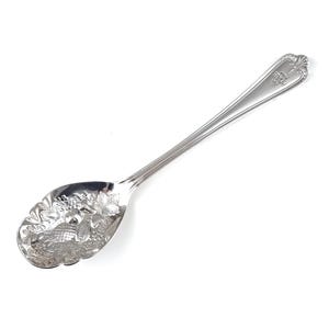 May include: A silver spoon with an ornate design featuring a bird and grapes. The spoon has a long handle with a decorative end.