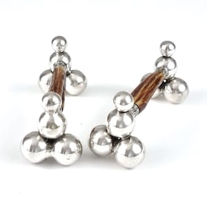 May include: A pair of silver and antler knife rests. Each rest has a stack of three silver spheres on each end and a brown antler in the middle.