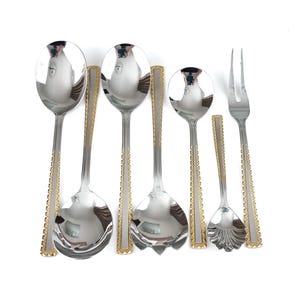 Puede incluir: Un juego de seis utensilios de servir de acero inoxidable con adornos dorados. El juego incluye cucharas de varios tamaños y un tenedor. Las cucharas tienen un diseño clásico con un acabado pulido.