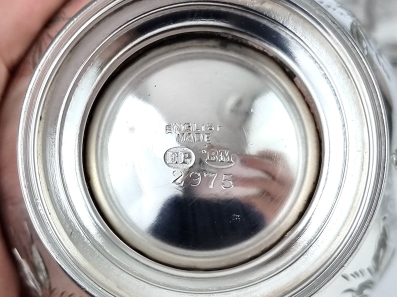 May include: Close-up of the bottom of a silver object with the inscription "English Made" and the numbers "2975".