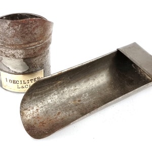 Pu&ograve; includere: Due bicchieri di misura in metallo vintage. Uno &egrave; un bicchiere da 1 decilitro con un'etichetta che recita "1 Decilitro L&Co.". L'altro &egrave; un bicchiere a forma di cucchiaio.