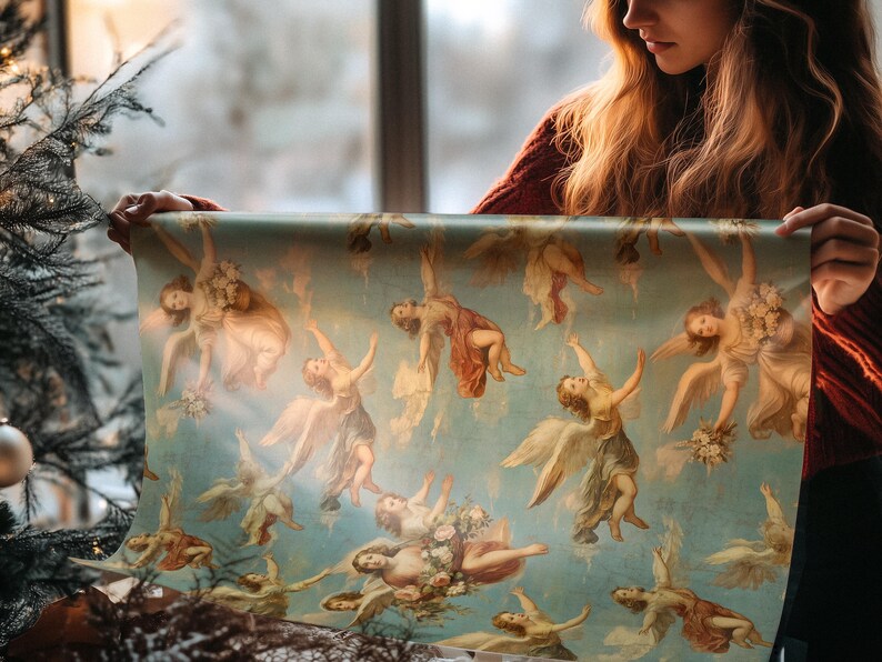 A woman holds a roll of Angels Cherubim Antique Gift Wrap, showcasing a vintage design with cherubs. The scene is set near a softly lit window, creating a cozy atmosphere, ideal for holiday gift wrapping.