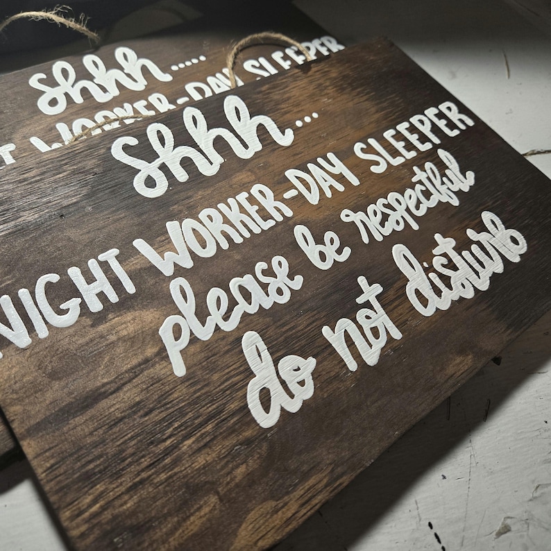 May include: A wooden sign with white text that reads "Shhh... Night worker-day sleeper please be respectful do not disturb".