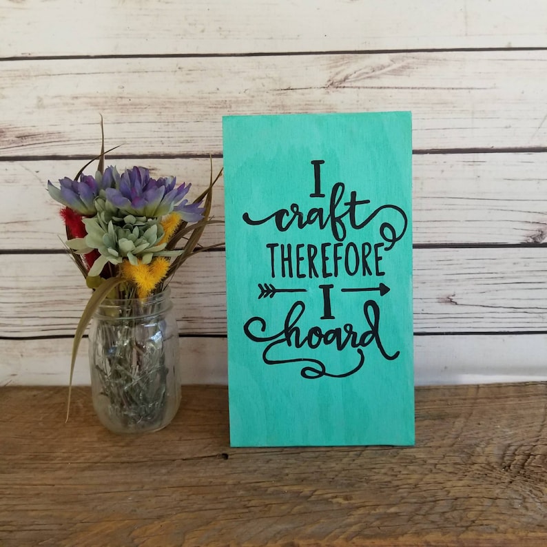 May include: A teal wooden sign with black lettering that reads "I craft therefore I hoard".