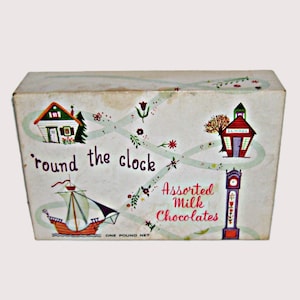 May include: Vintage rectangular box with a light background, featuring illustrations of a house, school, ship, and clock. The box reads "round the clock" and "Assorted Milk Chocolates". The net weight is one pound.