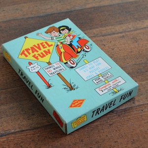 May include: A blue box with the words "Travel Fun" on the front. The box contains a game for ages 5 to 12 with activities to do while traveling, games to play, US map fun, puzzles, jokes and riddles. The box is complete with 2 wiplon crayons and an eraser.