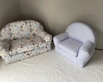 May include: Two small armchairs, one with a floral pattern and the other with a white and blue striped pattern.