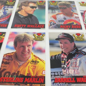 May include: A collection of racing trading cards featuring various NASCAR drivers. The cards display portraits of drivers like Mark Martin, Rusty Wallace, and Ricky Rudd, along with their names and sponsor logos. The cards are from the Crown Jewels series.