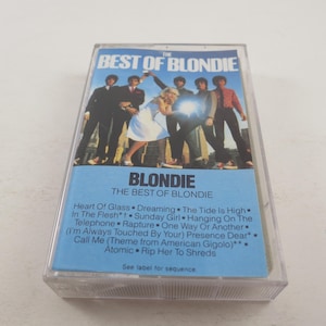 May include: A cassette tape case with a blue background and a photo of the band Blondie. The text on the case reads "The Best of Blondie" and lists the songs included on the tape.