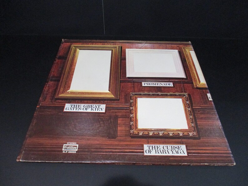 May include: A vintage vinyl record album cover featuring four empty picture frames against a wood-paneled background. The album is titled "The Great Gates of Kiev" and "The Curse of Baba Yaga" with the word "Promenade" written below one of the frames.