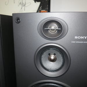 May include: A pair of black Sony 3-way speaker systems. Each speaker has three circular components and the word "SONY" and "3 WAY SPEAKER SYSTEM" are printed on the front.