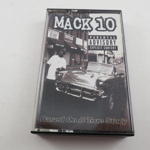 May include: A black and white cassette tape featuring the album cover for Mack 10's "Based On A True Story." The cover art includes a man in a white shirt, a classic car, and the Parental Advisory Explicit Content warning.