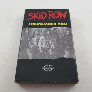 May include: A black cassette tape featuring a band photo of Skid Row. The text on the tape reads "Skid Row" and "I Remember You".
