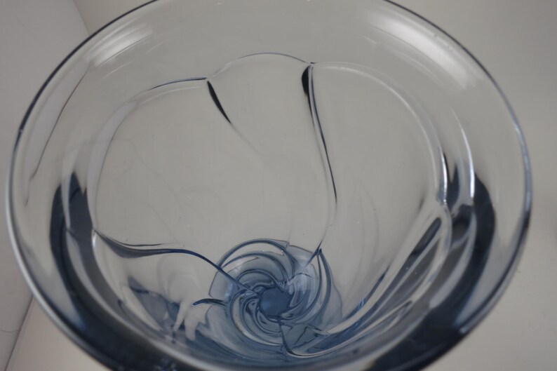 Pu&ograve; includere: Un vaso di vetro trasparente tinto di blu con un design a spirale unico. Il vaso ha una parte superiore ampia e aperta e una forma arrotondata e curva. L'interno presenta un motivo a spirale, creando un aspetto elegante e artistico. Ideale per l'arredamento della casa.