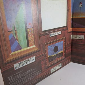 Puede incluir: Portada de &aacute;lbum con obras de arte enmarcadas en una pared con paneles de madera. El arte incluye formas abstractas, un c&iacute;rculo negro y un paisaje surrealista. Los t&iacute;tulos incluyen "The Great Gates of Kiev" y "The Curse of Baba Yaga."