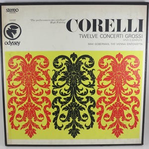 May include: A vintage vinyl record album titled "Corelli Twelve Concerti Grossi." The album cover features a black frame with a cream-colored top section and a yellow lower section. The yellow section has a repeating red and black floral design.