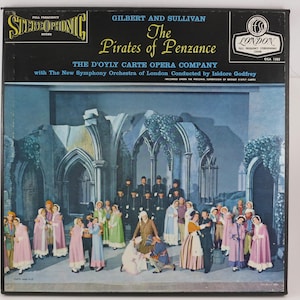 May include: A square vinyl record cover for Gilbert and Sullivan's The Pirates of Penzance by The D'Oyly Carte Opera Company. The cover features a black top section with white and yellow text and a large illustration of a costumed opera cast.