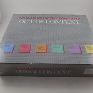 May include: A boxed board game titled "A Game of Outrageous Quotes Out of Context." The box is gray with a grid pattern and colorful sticky notes. The game is sealed in clear plastic wrap.