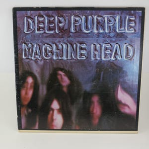 May include: Album cover for Deep Purple's "Machine Head." The album art features the band's name and album title in a raised, metallic-style font. The background is a dark, blurred image of the band members.