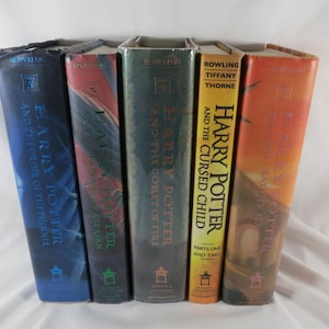 May include: A collection of five hardcover books standing upright, including Harry Potter and the Order of the Phoenix, Harry Potter and the Prisoner of Azkaban, Harry Potter and the Goblet of Fire, Harry Potter and the Cursed Child, and Harry Potter and the Deathly Hallows.