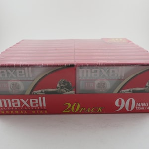 May include: A pack of 20 Maxell audio cassette tapes. The tapes are 90 minutes long and have a normal bias. The pack is red and white and has a picture of a lion on it.