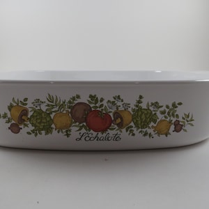 May include: White rectangular baking dish with a decorative border of colorful vegetables and the text "L'échalote". The dish has two small handles and is suitable for oven use.
