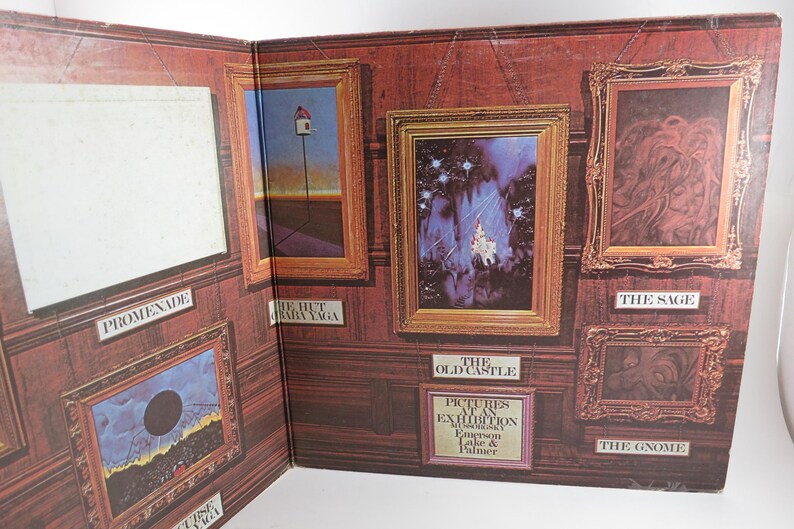 Puede incluir: Un &aacute;lbum abierto con obras de arte enmarcadas en una pared con paneles de madera. El &aacute;lbum se titula "Pictures at an Exhibition" de Emerson, Lake & Palmer. Las obras de arte incluyen paisajes y dise&ntilde;os abstractos, con t&iacute;tulos como "The Sage" y "The Gnome".