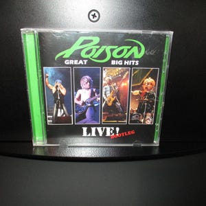 May include: A green and black CD case with a picture of the band Poison on the front. The title of the album is "Great Big Hits Live! Bootleg".