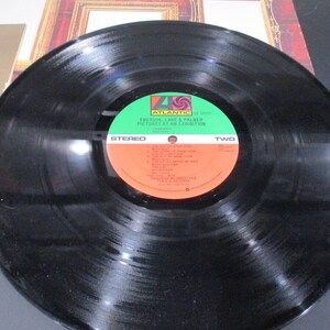 May include: Black vinyl record with a green and red label. The label reads "Atlantic" and "Emerson, Lake & Palmer Pictures at an Exhibition". The record is side two.