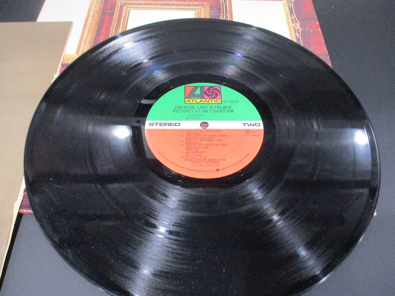 May include: Black vinyl record with a green and red label. The label reads "Atlantic" and "Emerson, Lake & Palmer Pictures at an Exhibition". The record is side two.