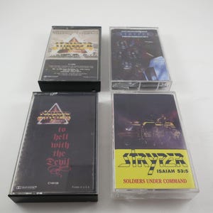 May include: Four cassette tapes with black cases and colorful covers. The covers feature the band Stryper with the titles "To Hell With The Devil", "Soldiers Under Command", "Isaiah 53:5", and "The Yellow And Black Attack".