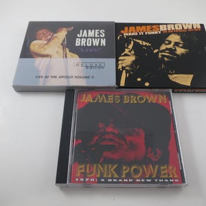 May include: Three James Brown music CDs. One is Live at the Apollo Volume II Deluxe Edition with a yellow-toned photo. Another is Make It Funky The Big Payback 1971-1975 with a black and white photo. The third is Funk Power 1970: A Brand New Thang.