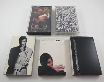 May include: Five cassette tapes, four with black and white images and one with a black background. The tapes are labeled "Faith George Michael" and "George Michael AE".