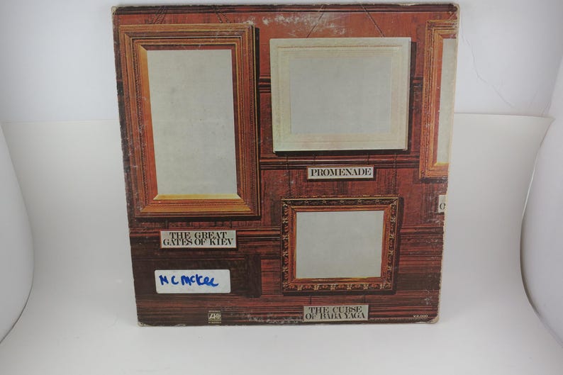 Puede incluir: Portada de &aacute;lbum con obras de arte enmarcadas sobre un fondo de madera oscura. El texto incluye "The Great Gates of Kiev", "Promenade" y "The Curse of Baba Yaga". El nombre "MC McKel" est&aacute; escrito con un rotulador azul.