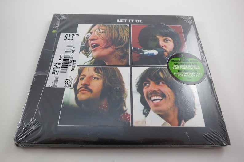 May include: Sealed vinyl record of The Beatles' album "Let It Be." The album cover features four individual portraits of the band members. The album is in a plastic wrap with a price tag and a green sticker.