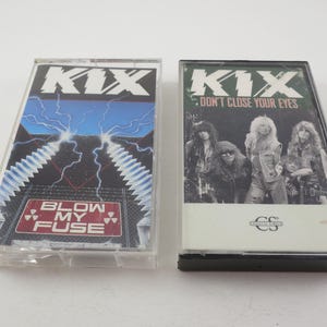May include: Two cassette tapes by the band KIX. The first tape is titled "Blow My Fuse" and features a black and white image of lightning bolts and a red sign with the title. The second tape is titled "Don't Close Your Eyes" and features a black and white image of the band members.