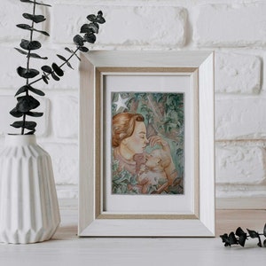 May include: A framed watercolor painting of a mother and child. The mother is holding the child in her arms and they are both looking at each other. The painting is set against a background of green leaves and a single white star.