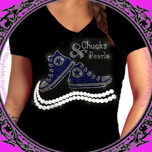 May include: Black t-shirt with a rhinestone design of blue sneakers and a pearl necklace. The text "Chucks & Pearls" is also included in rhinestones.
