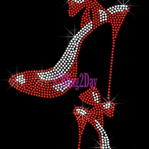 May include: Red and white rhinestone high heel shoe design. The shoe is outlined in white rhinestones and the rest of the shoe is red rhinestones. The shoe has a bow on the top.