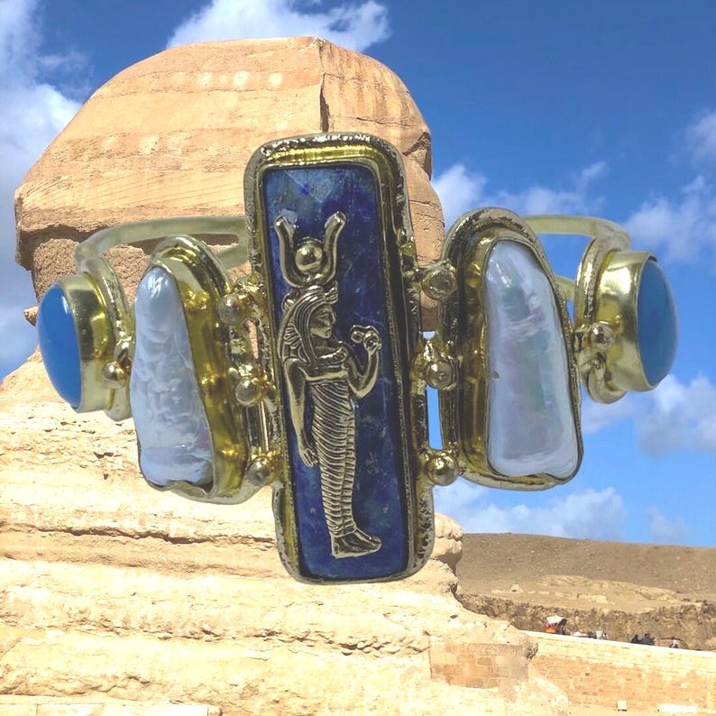 This Ancient Egyptian Isis charm features a Lapis Lazuli stone on a cuff bracelet embellished with 2 white pearls and 2 blue agate stones. image 4
