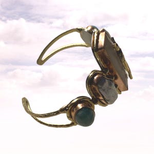 This Ancient Egyptian Isis charm features a Lapis Lazuli stone on a cuff bracelet embellished with 2 white pearls and 2 blue agate stones. image 3
