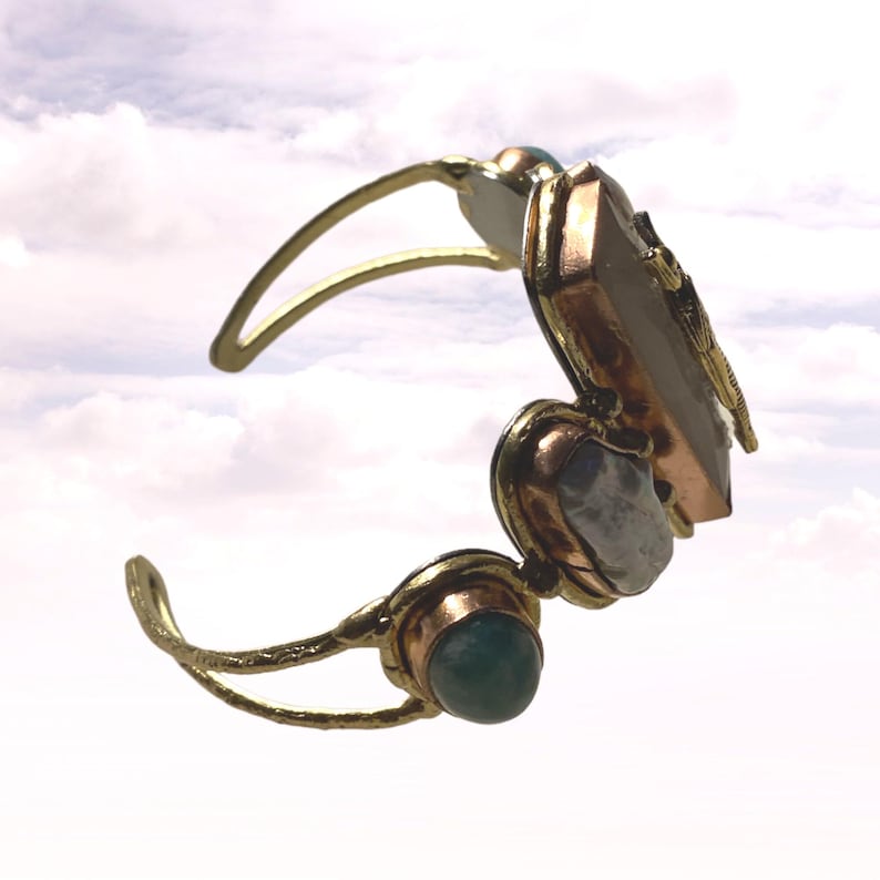 This Ancient Egyptian Isis charm features a Lapis Lazuli stone on a cuff bracelet embellished with 2 white pearls and 2 blue agate stones. image 3