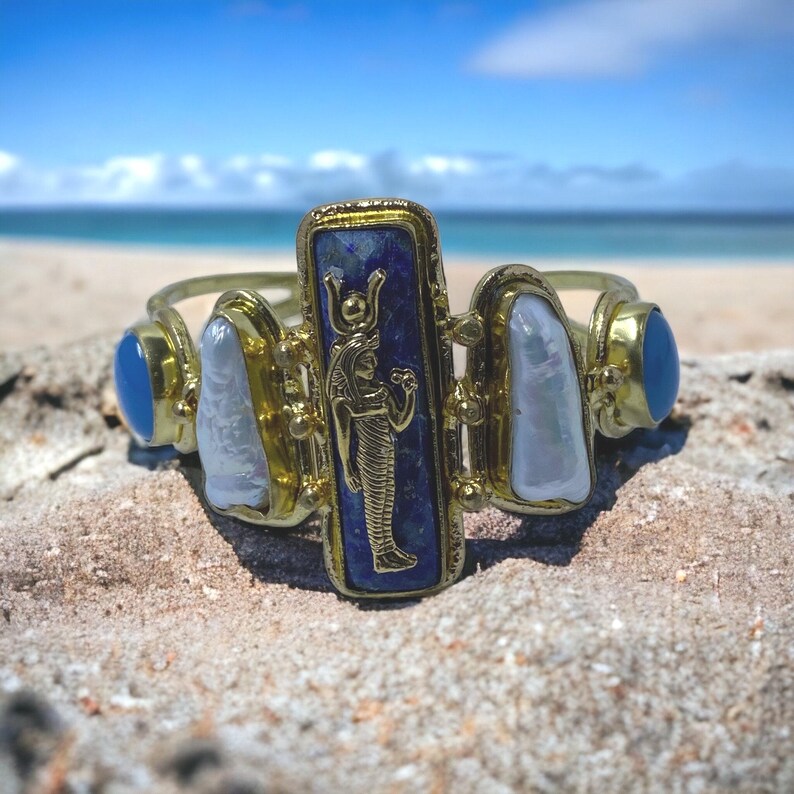 This Ancient Egyptian Isis charm features a Lapis Lazuli stone on a cuff bracelet embellished with 2 white pearls and 2 blue agate stones. image 10